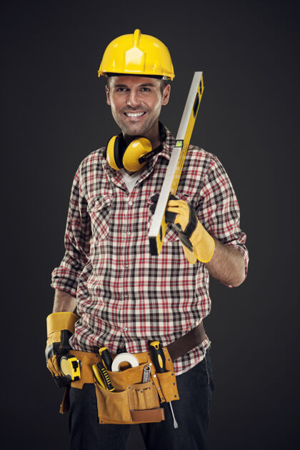 黄色笑容可掬的建筑工人举着测量器自信工作测量仪器