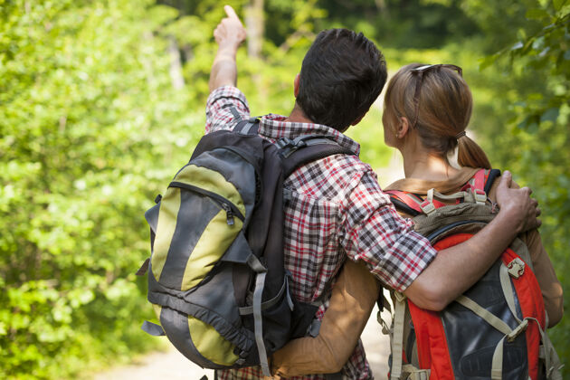 年轻人情侣在森林里徒步旅行假期风景人际关系