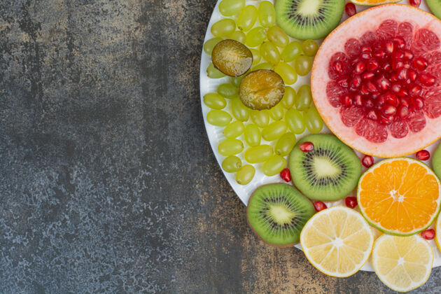 盘子水果沙拉配石榴 葡萄柚和猕猴桃在白色盘子上高品质照片葡萄甜的水果