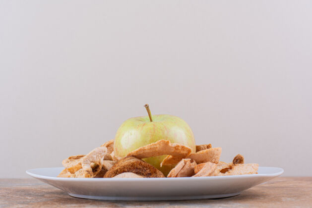 好吃白色的干苹果戒指和新鲜的绿色苹果放在大理石桌上高品质的照片小吃食品苹果
