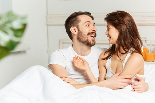 枕头年轻的异性恋夫妇躺在卧室的床上爱丈夫家庭