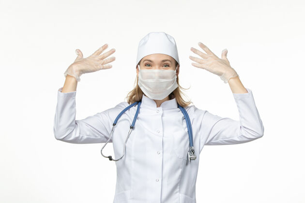 灯光正面图女医生穿着医疗服戴着口罩和手套因冠状病毒对光台病毒冠状病毒-大流行性疾病肖像穿戴正面