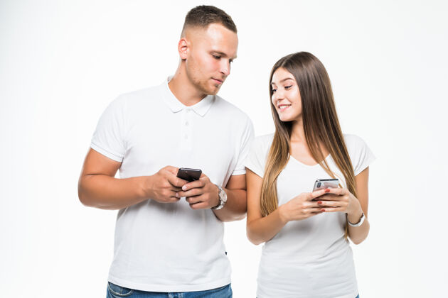 看美丽的情侣看着彼此手机上的白色隔离抱着手机手