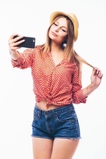 她自己一个微笑的可爱女人在智能手机上自拍的照片 白色背景上的隔离电话肖像手机