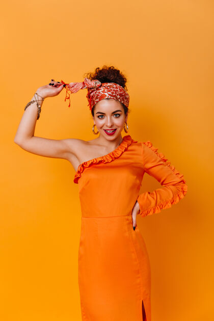 服饰身材苗条的女士身着优雅的橙色连衣裙 头戴非洲风格的头巾 在橙色的空间里露出甜美的笑容化妆现代瘦身