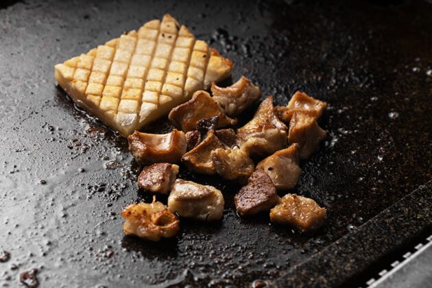 新鲜高角度拍摄美味的油炸肉和土豆在一个黑色托盘上美食牛肉食物