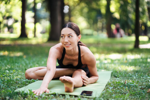 私人教练早上在公园练瑜伽的运动型年轻女子白种人减肥冥想