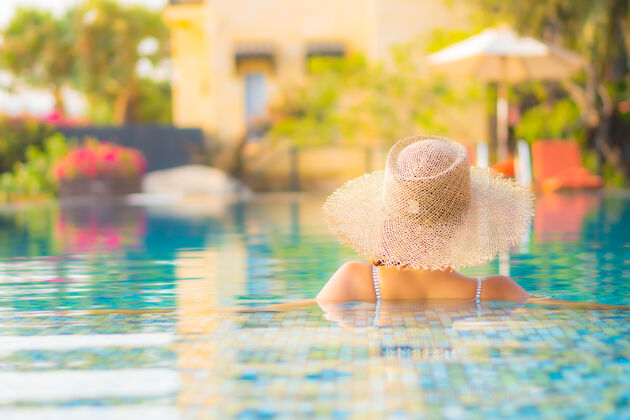 旅游肖像美丽的亚洲年轻女子放松微笑在度假酒店游泳池周围享受休闲度假度假阳光游泳