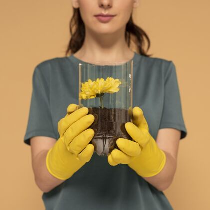 花特写镜头女人在塑料瓶里种了花再利用近距离零浪费