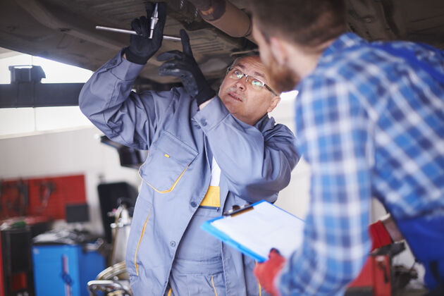 工作工具修理工在车间里修理汽车合作伙伴关系人
