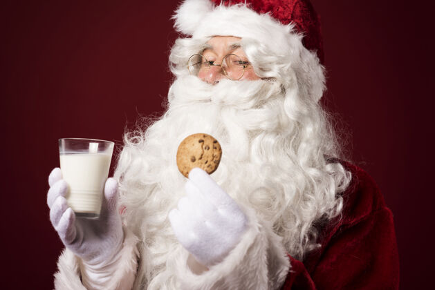 站圣诞老人拿着饼干和牛奶杯季节牛奶欢乐