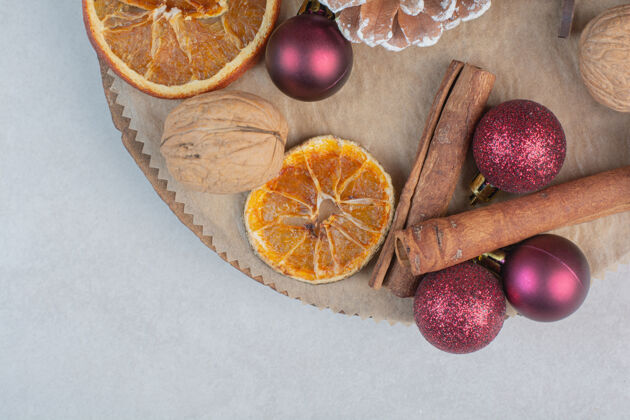 盘子核桃与松果和圣诞球在木板上高品质的照片红球核桃健康
