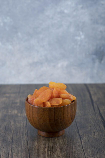 堆一碗健康的杏干放在木桌上橘子甜美味