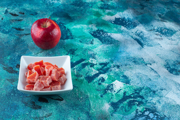 美味苹果和红色果酱放在蓝色的碗里风味收获甜点
