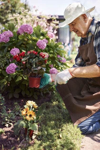 体力劳动者拿着花在地里干活的老人植物农场职业