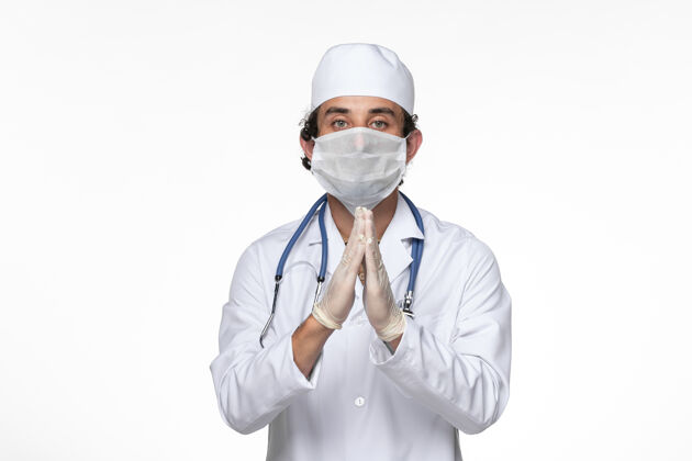 男性正面图身穿医疗服的男医生戴着无菌口罩 以防感染白色桌上病毒疾病消毒医疗病毒