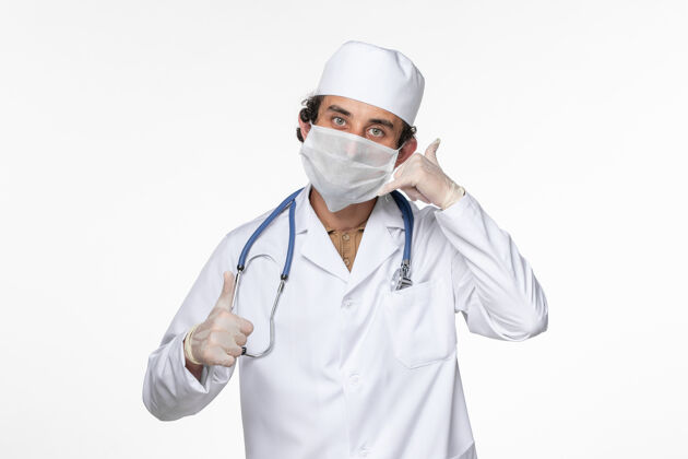 正面正面图男医生穿着医疗服 戴着无菌口罩 以防白壁病毒上冠状病毒大流行疾病穿戴面罩外套