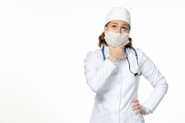 到期因冠状病毒和思考白墙大流行病毒疾病冠状病毒 身穿白色医疗服 戴着口罩的女医生女性面具护士