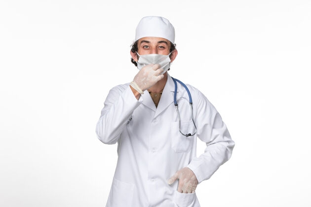 防护正面图：男医生穿着医疗服 戴着面罩 以防白色冠状病毒大流行大流行医生听诊器