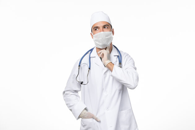 制服正面图：男医生穿着医疗服 戴着口罩 因为白墙病毒感染了柯维德大流行性疾病冠状病毒防护医生专业人员