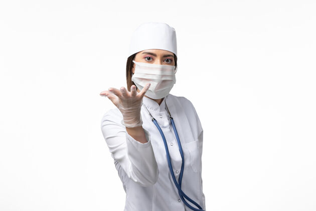 疾病正面图女医生穿着白色医疗服 戴着口罩 因冠状病毒对光壁病的传播医学病毒大流行covid-微笑女性正面
