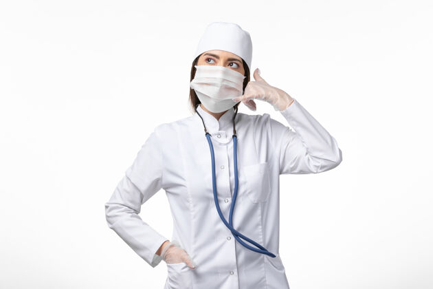 套装正面图女医生身穿白色无菌医疗服 带口罩 因白墙上冠状病毒病大流行冠状病毒面具冠状病毒预防正面
