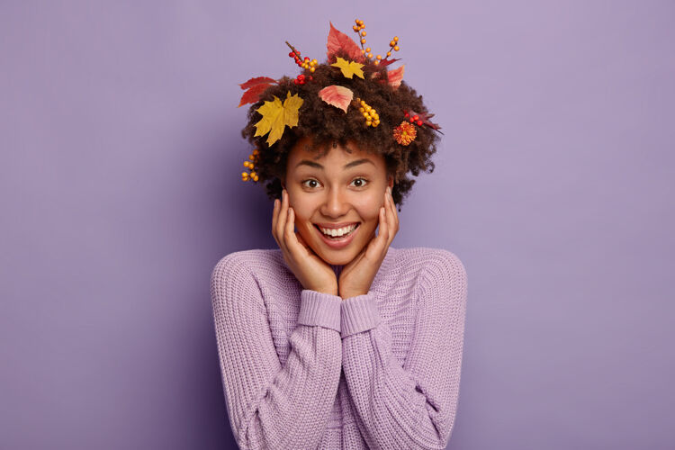 套头衫满头秋叶的开朗少女 微笑着直视镜头 穿着紫色针织毛衣 有着快乐的季节心情针织女人请