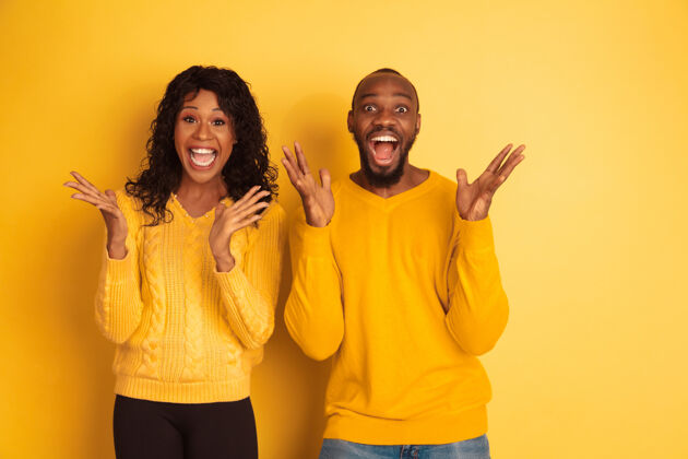 男人年轻感性的非裔美国人男女穿着鲜艳的休闲服在黄色的空间里摆姿势美丽的情侣情感女性广告