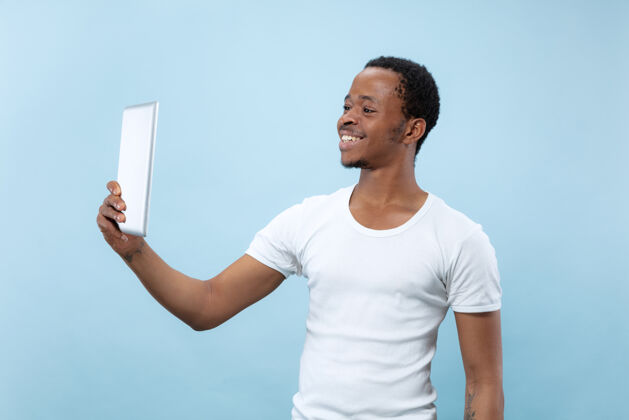 Vlog半身特写肖像的年轻非洲裔美国人在白衬衫上的蓝色空间长度男性专业
