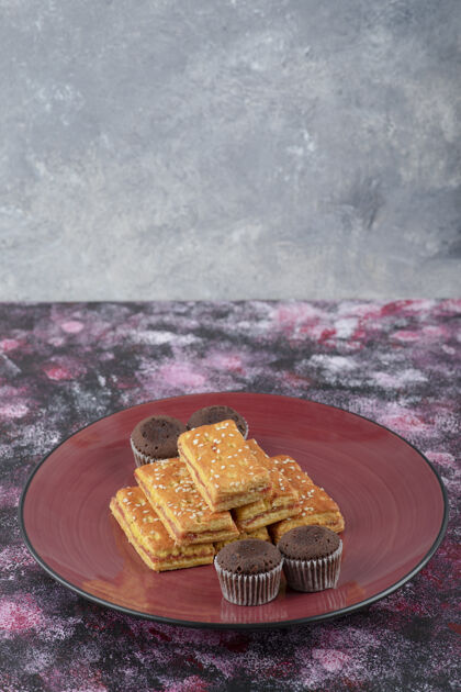 甜点美味的可可饼干和脆饼干放在红盘子里烘焙吃的饼干