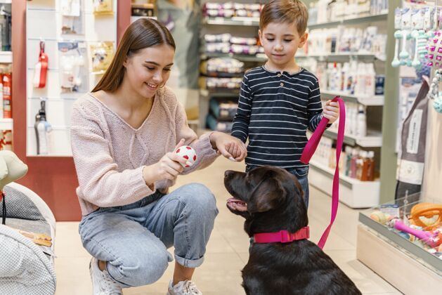 品种孩子和妈妈在宠物店和他们的狗购买狗血统