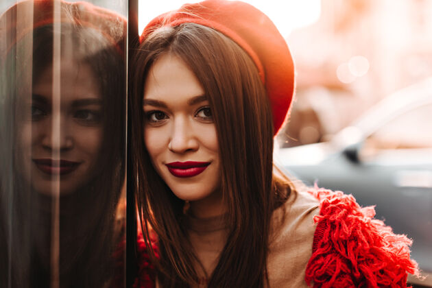 年轻褐色眼睛 皮肤黝黑 嘴唇红润的女士靠在窗户上看着摄像机休闲模特黑发