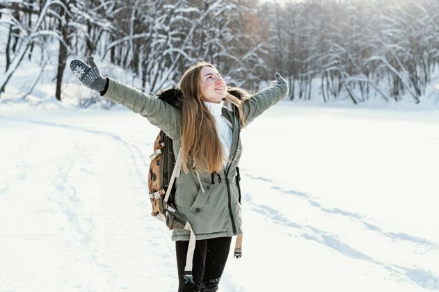 女人冬天背着背包的肖像女人背包自然全景