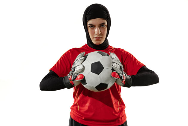 动作阿拉伯女足或足球运动员 守门员 背景为白色工作室年轻女子自信地摆出持球姿势 为球队进球保驾护航运动训练保护
