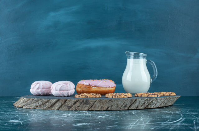 玻璃杯很多甜的糖果和牛奶在一个黑暗的董事会高品质的照片饮料平铺盘子