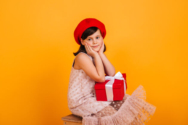 盒子梦幻般的孩子拿着生日礼物摆姿势戴着红色贝雷帽的未成年女孩拿着新年礼物小节日童年