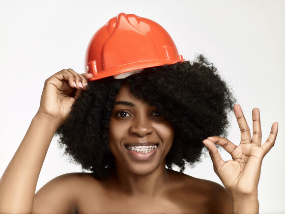 头盔戴着橙色头盔的自信女工画像皮肤护理保护建设者