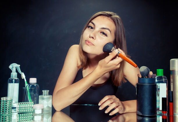 护理美女化妆美女照镜子 用大刷子化妆工作室里的白种人模特女性过程人