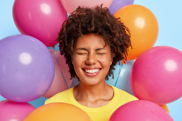 肖像兴奋的 喜出望外的年轻女子在生日彩球的簇拥下摆姿势欢乐欣喜若狂庆祝