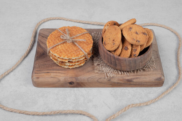美味华夫饼和一碗饼干在白色的表面高品质的照片面包房甜点绳子