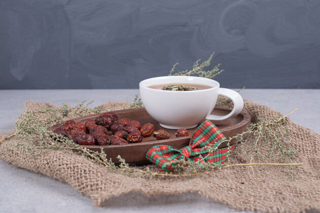 可食用一杯茶和干蔓越莓放在粗麻布上高质量的照片叶蔓越莓茶