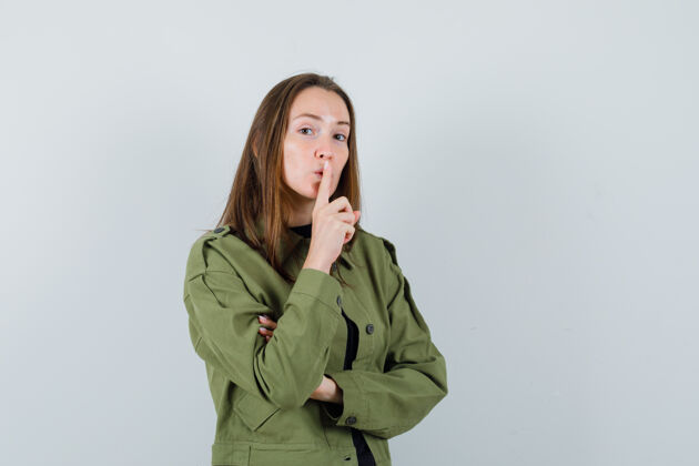 成人身着绿色夹克的年轻女子表现出沉默的姿态 神情凝重正面视图青春时尚快乐