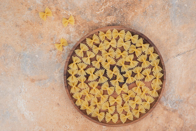 生的蝴蝶结意大利面在大理石背景的木板上高品质的照片领结通心粉美味