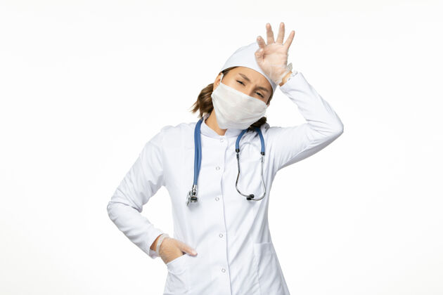 外套正面图年轻女医生戴着无菌口罩和防护手套 因为白色表面有冠状病毒手套防护到期