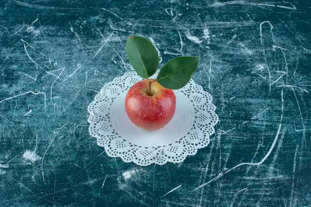 天然美味的苹果在doily上 在蓝色的背景上高质量的照片水果Doily美味