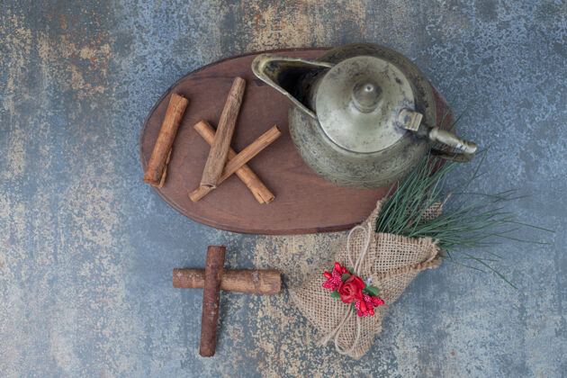 肉桂经典的茶壶和肉桂棒在木板上高品质的照片顶视图花装饰品