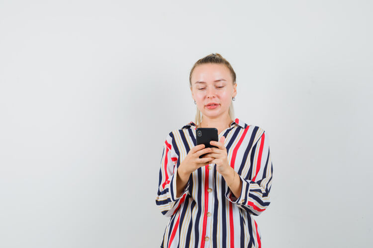 女士穿着条纹衬衫的年轻女士正在检查她的手机老年人肖像女人