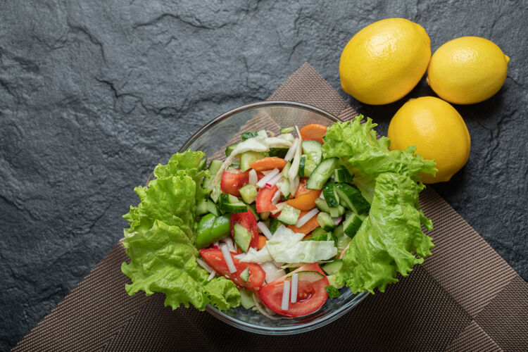 烹饪黑色背景上的柠檬健康蔬菜沙拉特写照片高品质照片美食洋葱乡村