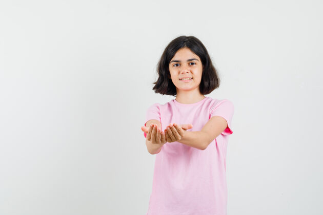 青年穿着粉色t恤的小女孩伸出杯状的手 看上去很快乐正视图杯青少年未成年
