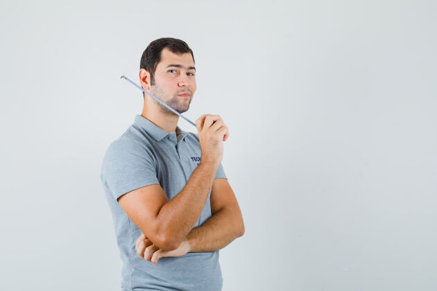 磁带身穿灰色制服的年轻技术员拿着卷尺 站在思考的姿势 神情沉思工程师工业人